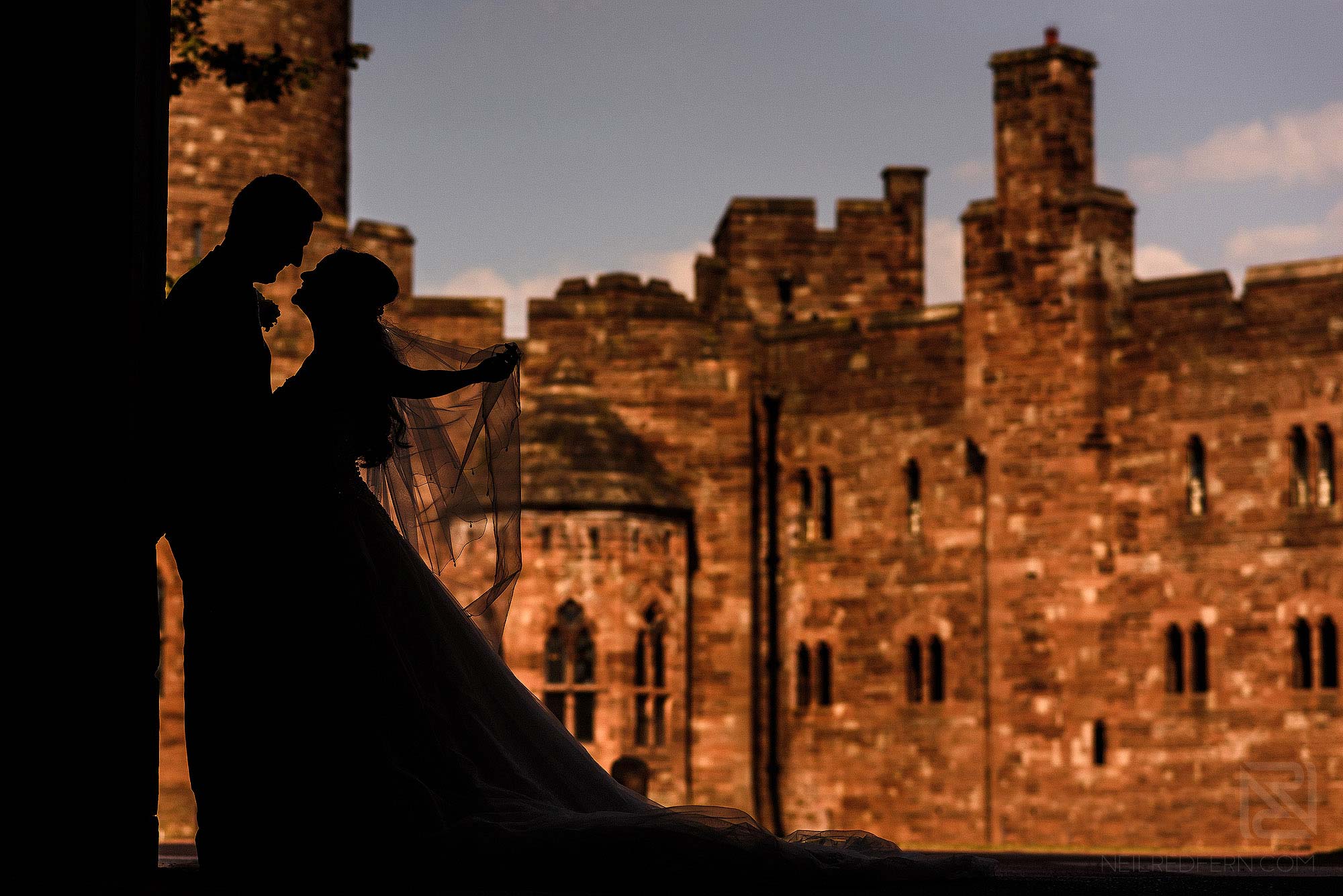 silhouette photograph of bride and groom outside Peckforton Castle