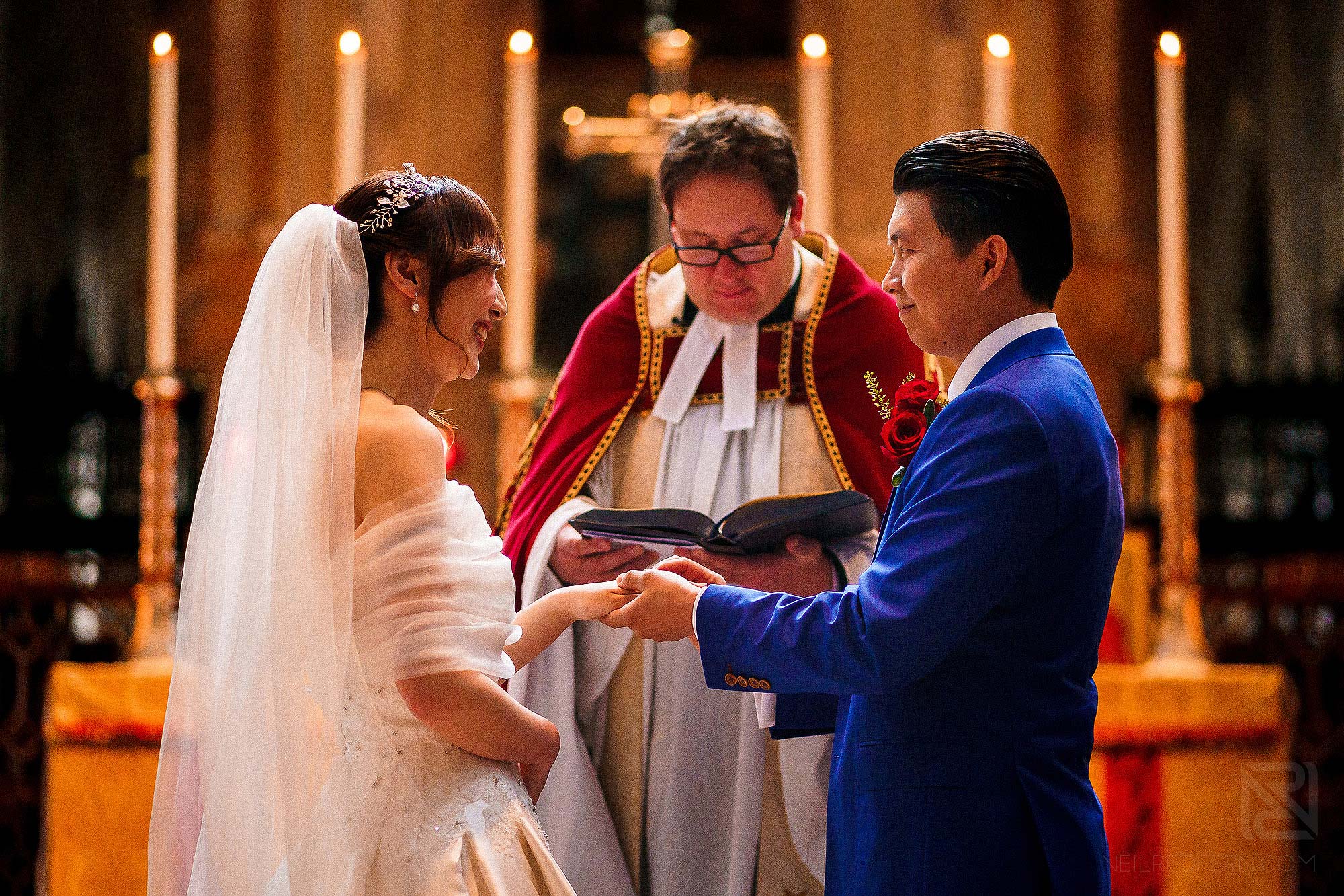 exchanging wedding vows during ceremony at St Bartholomew-the-Great in London
