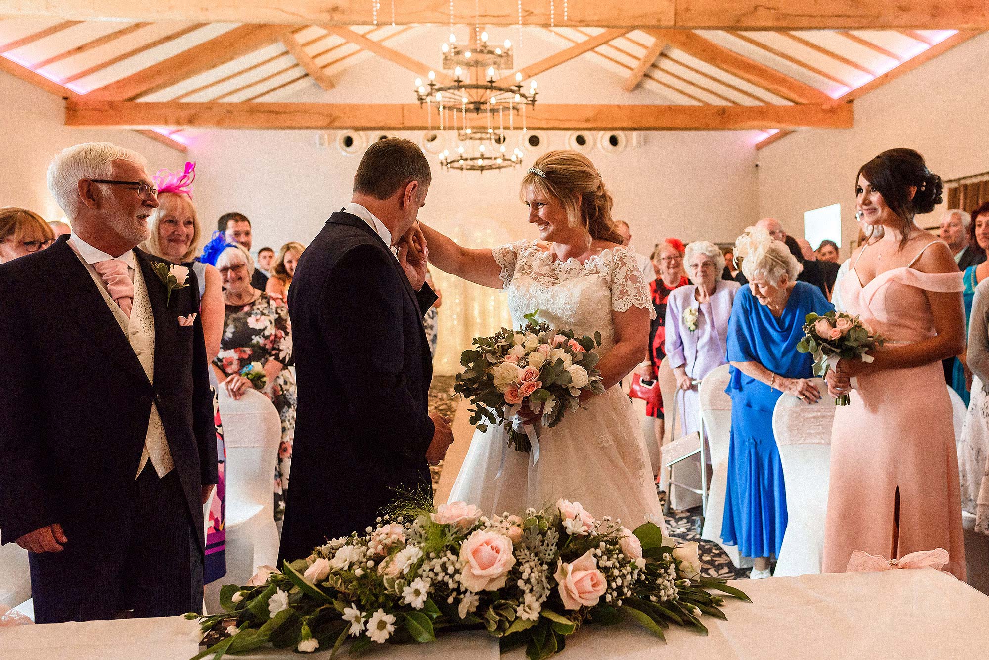 groom kissing hand of bride during wedding ceremony