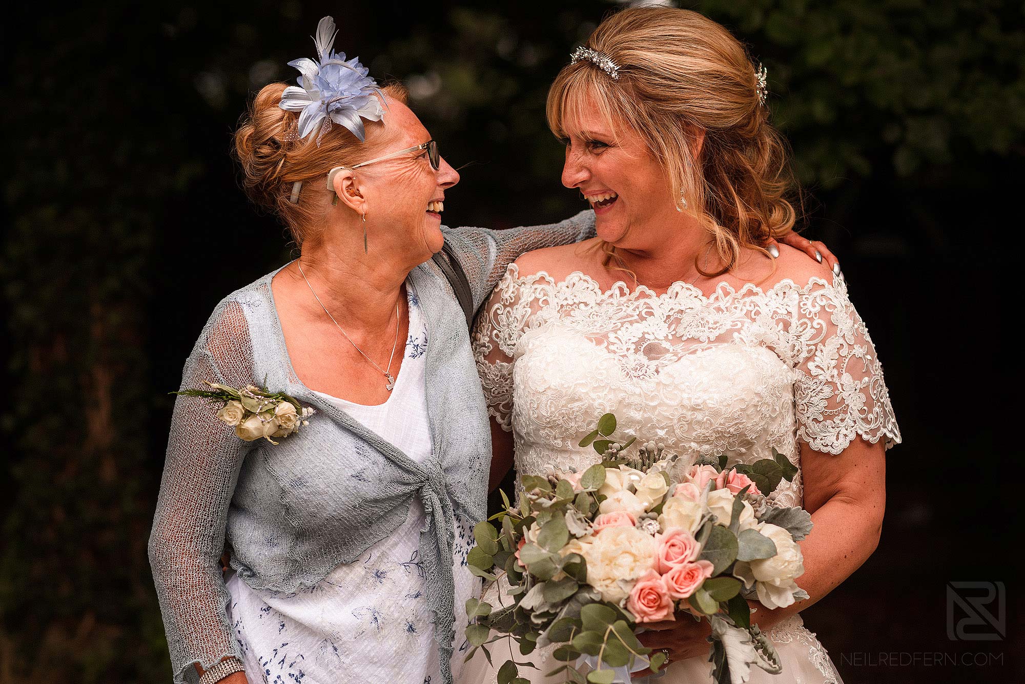 bride and best friend smiling at each other