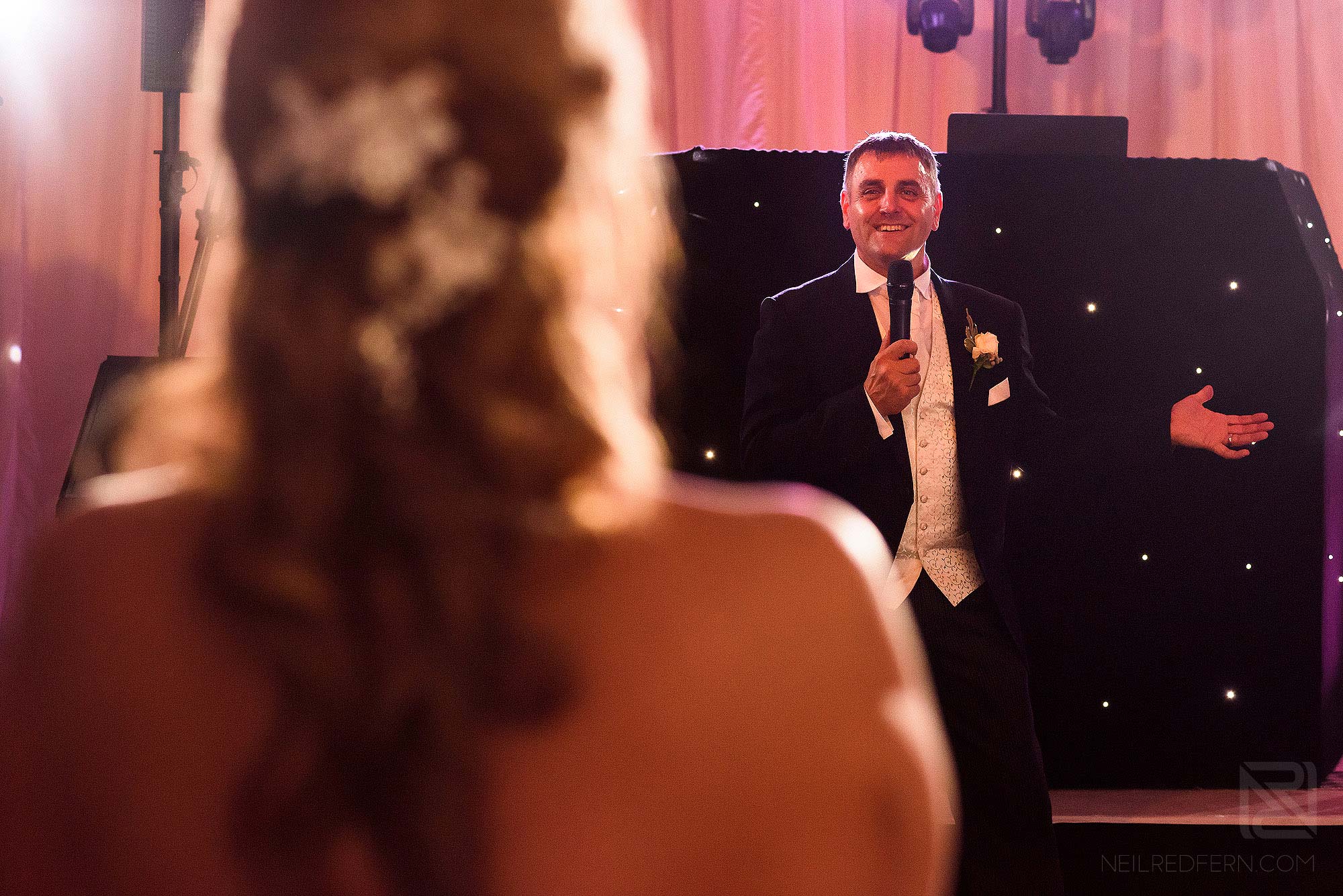groom singing to bride during wedding reception