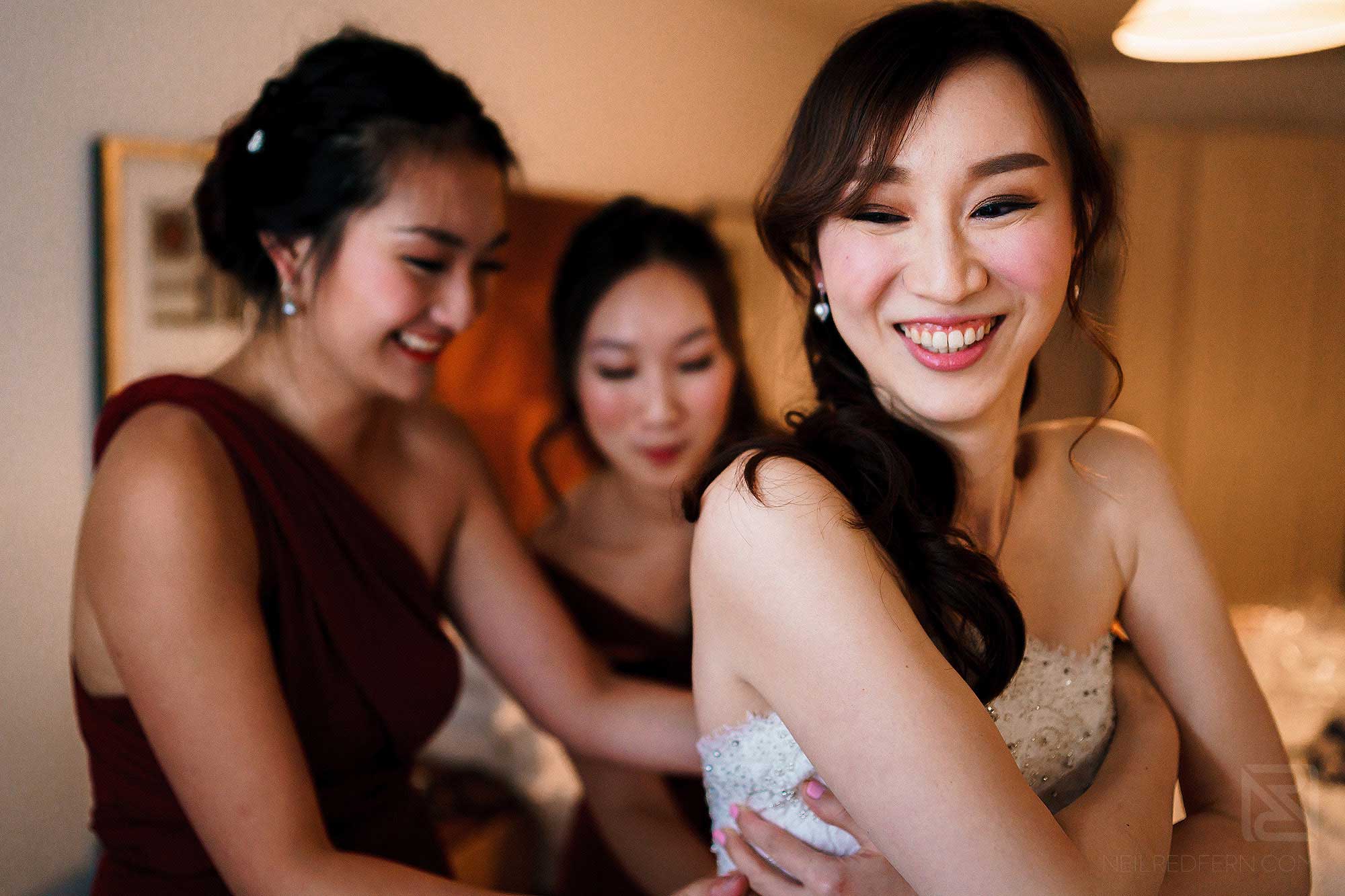 bride putting on wedding dress