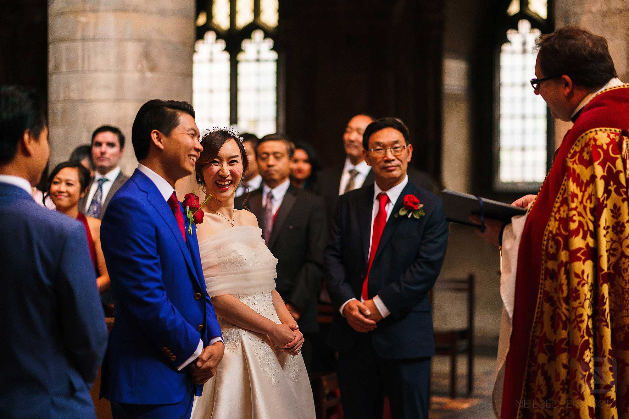 bride laughing during wedding service at St Bartholomew the Great in London