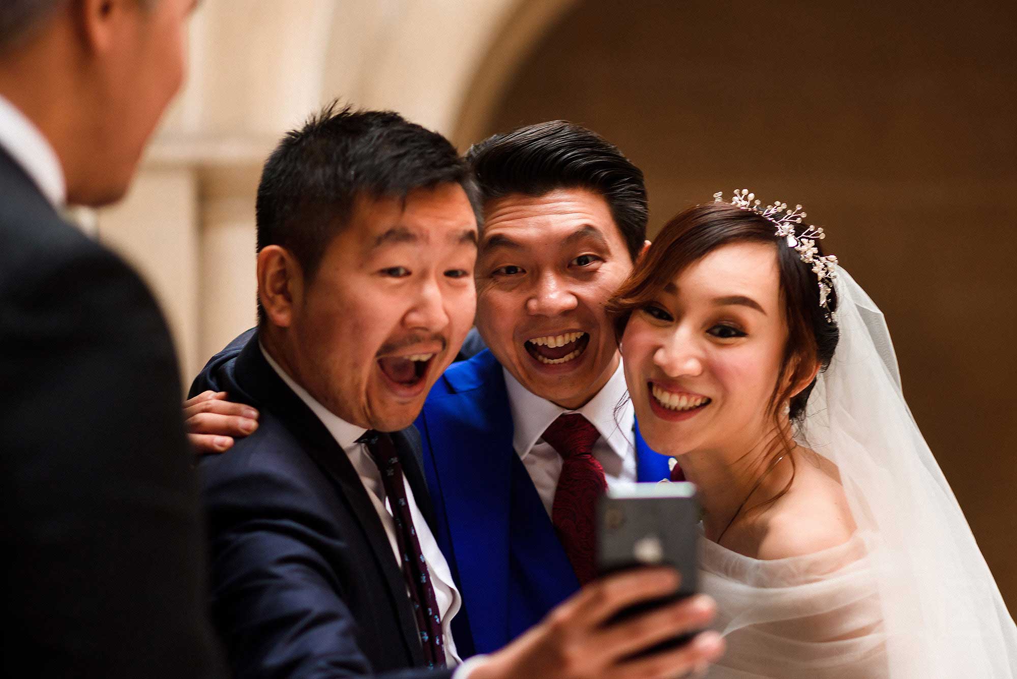 newlyweds laughing with guest