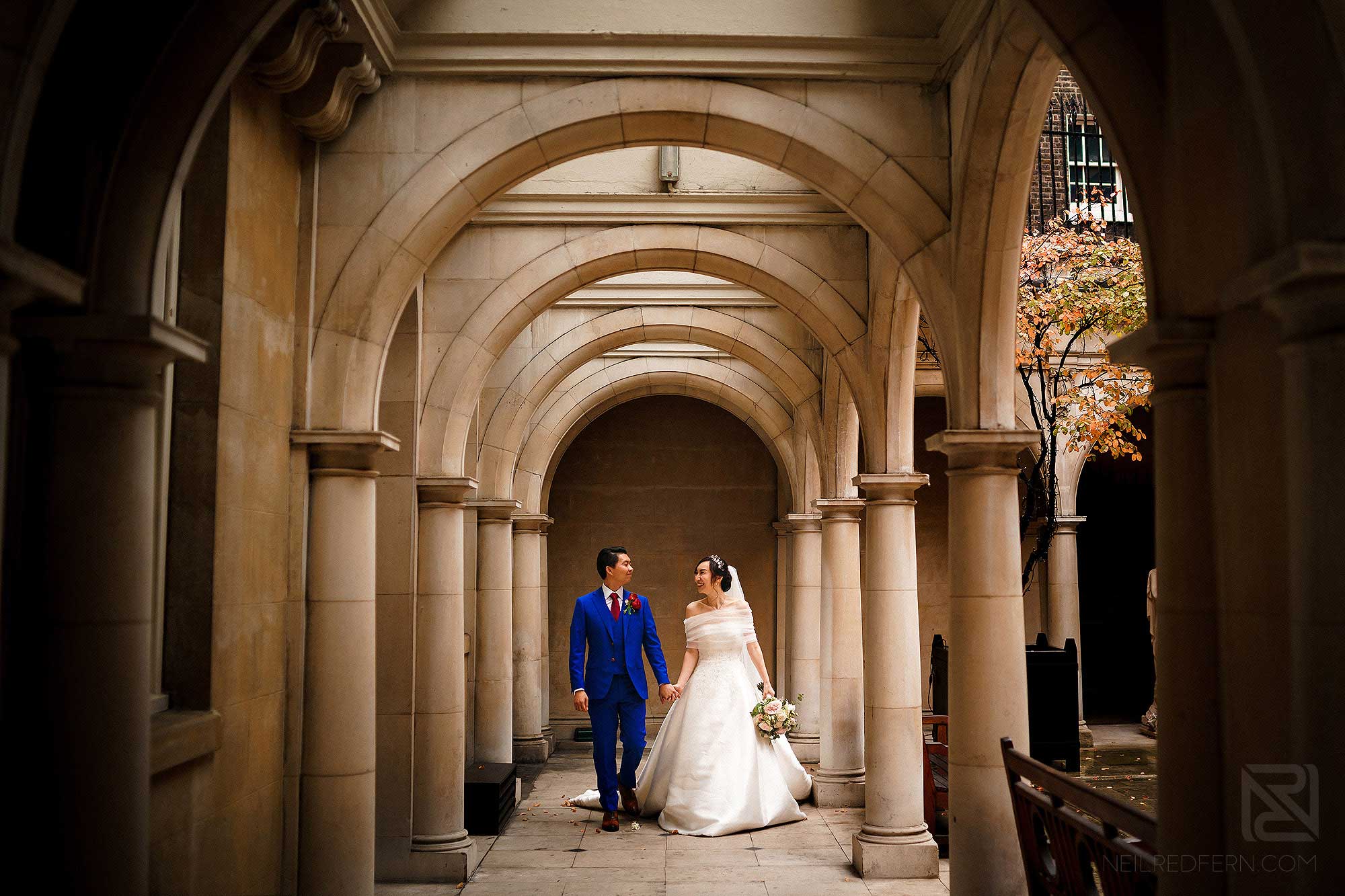 bride and groom walking together in Skinner's Hall in London