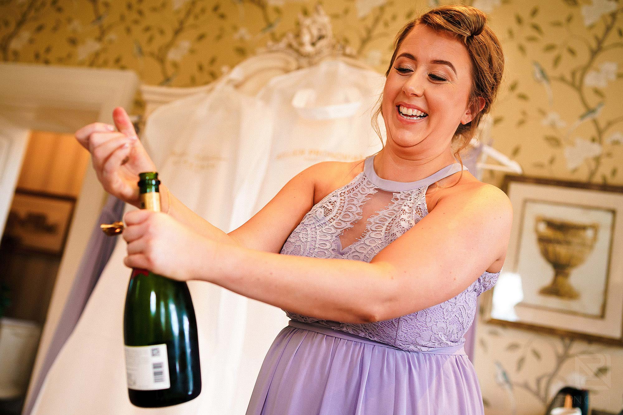 bridesmaid opening champagne
